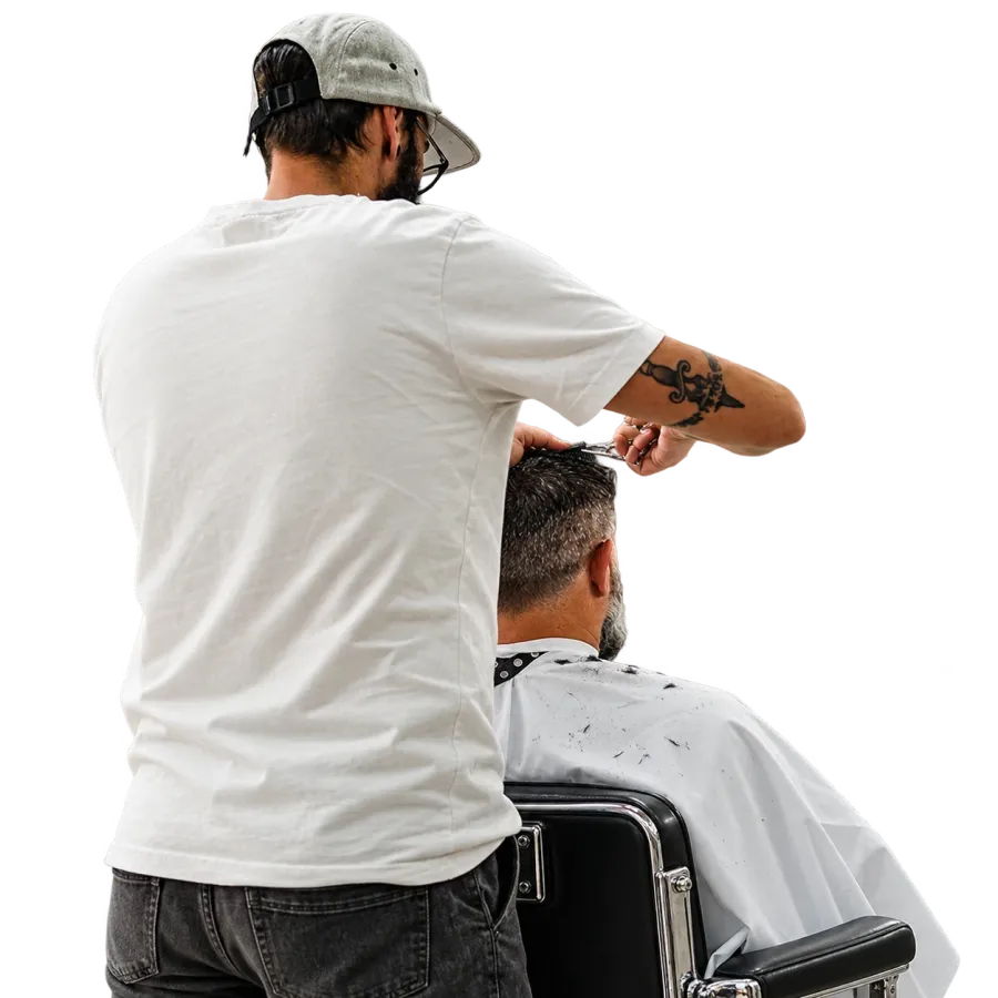 A barber cutting a client’s hair, seen from behind.