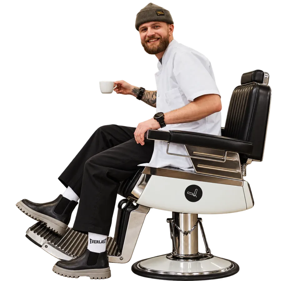 A barber taking a coffee break in his chair.